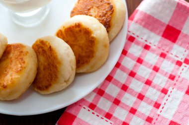 Bir çatal ile pembe bir peçete üzerinde beyaz bir tabak üzerinde ekşi krema ile Peynir krep, üst görünümü. Menü tasarımı için kullanılabilir.