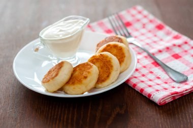 Pembe peçete ve çatal ile beyaz bir tabak üzerinde ekşi krema ile Peynir krep. Menü tasarımı için kullanılabilir.