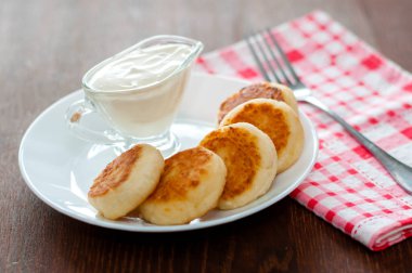 Pembe peçete ve çatal ile beyaz bir tabak üzerinde ekşi krema ile Peynir krep. Menü tasarımı için kullanılabilir.