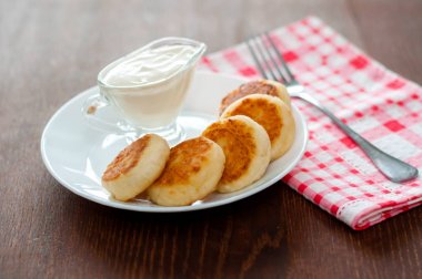 Pembe peçete ve çatal ile beyaz bir tabak üzerinde ekşi krema ile Peynir krep. Menü tasarımı için kullanılabilir.