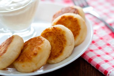 Beyaz bir tabak yakın çekim üzerinde ekşi krema ile Peynirkrep. Menü tasarımı için kullanılabilir.