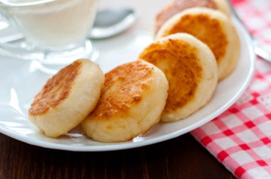 Beyaz bir tabak yakın çekim üzerinde ekşi krema ile Peynirkrep. Menü tasarımı, mutfak siteleri için kullanılabilir.