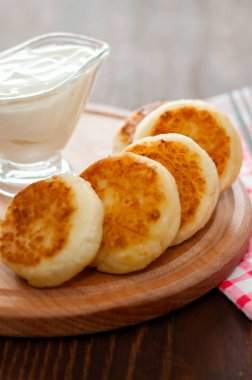 Ahşap bir tahta, dikey formatta ekşi krema ile Peynir krep. Menü tasarımı, mutfak siteleri için kullanılabilir.