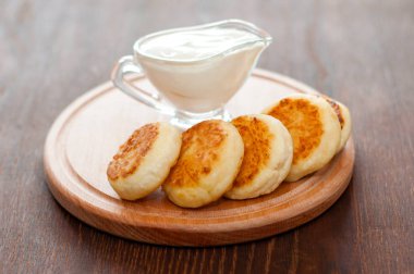 Ahşap bir tahta üzerinde ekşi krema ile Peynir krep, yatay formatta. Menü tasarımı ve cafe reklamcılığı için