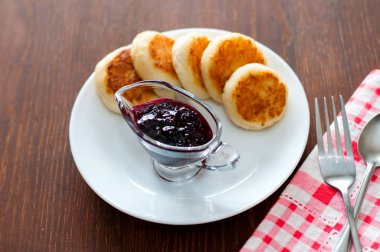 Kuş üzümü reçeli ile Peynir krep, bir çatal, bir çay kaşığı ve peçete ile beyaz bir tabak üzerinde, üstten görünümü.