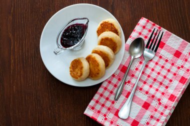 Reçelli peynirli krep, beyaz bir tabak tabakta, bir çay kaşığı, çatal ve mutfak havlusu ile, üstten görünümü