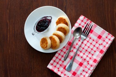 Reçelli peynirli krep, beyaz bir tabak tabakta, bir çay kaşığı, çatal ve mutfak havlusu ile, üstten görünümü