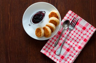 Reçelli peynirli krep, beyaz bir tabak tabakta, bir çay kaşığı, çatal ve mutfak havlusu ile, üstten görünümü