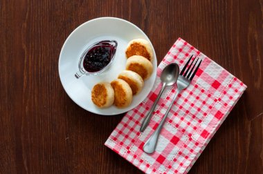 Reçelli peynirli krep, beyaz bir tabak tabakta, bir çay kaşığı, çatal ve mutfak havlusu ile, üstten görünümü