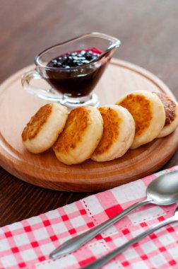 Reçelli peynirli krepler, ahşap bir platformda, üstten mutfak havlusu görünümünde, dikey fotoğraf