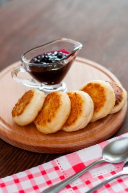 Reçelli peynirli krepler, ahşap bir platformda, üstten mutfak havlusu görünümünde, dikey fotoğraf