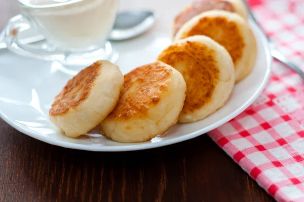 Käsepfannkuchen mit saurer Sahne auf einem weißen Teller in Großaufnahme. kann für die Gestaltung von Menüs, kulinarischen Orten verwendet werden. — Stockfoto