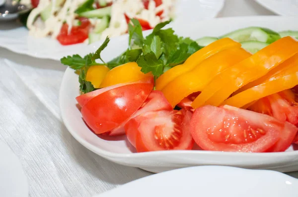 Λαχανικά σε φέτες, κόκκινη ντομάτα, κίτρινη πιπεριά στο τραπέζι των διακοπών. Πάρτι γενεθλίων — Φωτογραφία Αρχείου