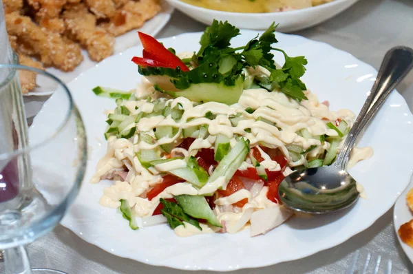 Σαλάτα με πράσινα λαχανικά, πιπεριές και ντομάτες με σάλτσα, μαγιονέζα ή ξινή κρέμα. Εορταστικό τραπέζι στο εστιατόριο — Φωτογραφία Αρχείου