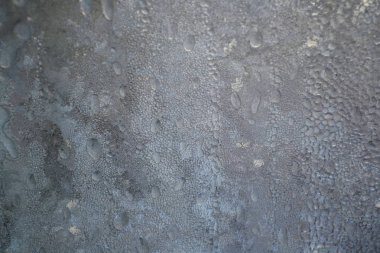 Kış arkaplanı, camın üzerindeki donmuş yağmur damlaları güçlü don ve rüzgardan, penceredeki buz dokusu.