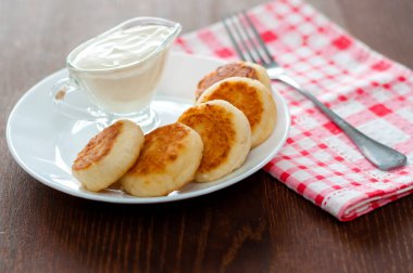 Pembe peçete ve çatal ile beyaz bir tabak üzerinde ekşi krema ile Peynir krep. Menü tasarımı için kullanılabilir.