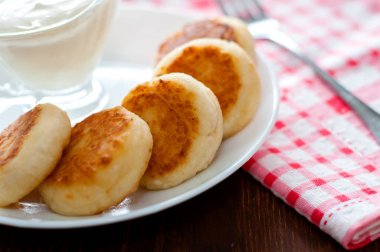 Beyaz bir tabak yakın çekim üzerinde ekşi krema ile Peynirkrep. Menü tasarımı için kullanılabilir.