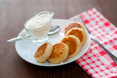 Üstten beyaz bir tabak görünümünde ekşi krema ile kızarmış peynir krep. Menü tasarımı için kullanılabilir.