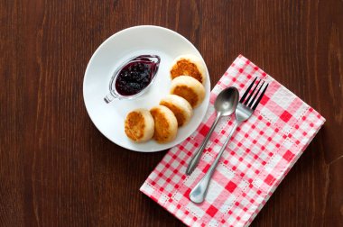 Reçelli peynirli krep, beyaz bir tabak tabakta, bir çay kaşığı, çatal ve mutfak havlusu ile, üstten görünümü