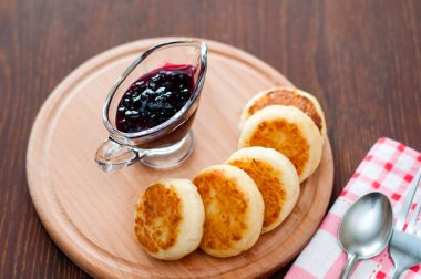 Kuş üzümü reçeli ile Peynir krep, tahta bir tahta üzerinde, bir çatal, kaşık ve bulaşık bezi görünümü ile üstten
