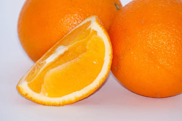 Апельсин на белом фоне, сочные плоды скользят крупным планом — стоковое фото