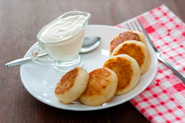 Üstten beyaz bir tabak görünümünde ekşi krema ile kızarmış peynir krep. Menü tasarımı için kullanılabilir.