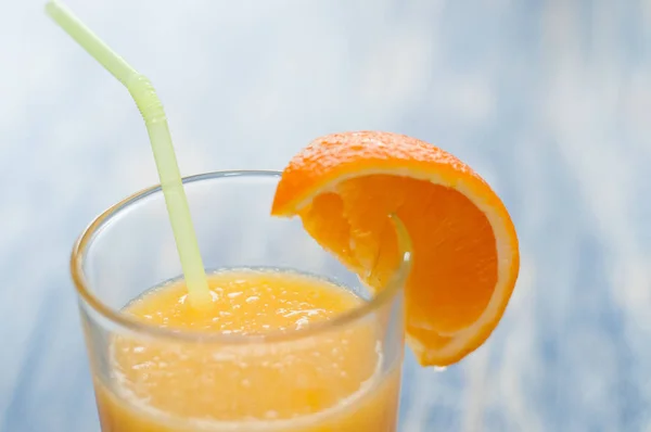 Alcoholic cocktail of fresh orange juice on a blue wooden background, copy space, closeup — Stock Photo, Image