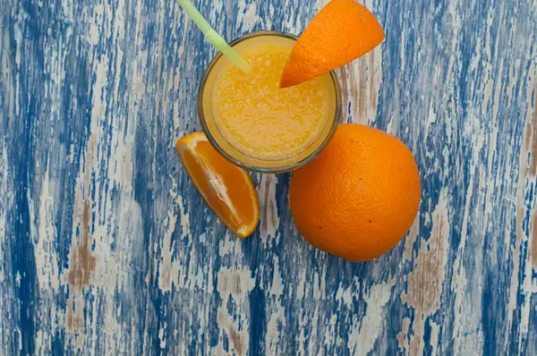 Свежий апельсиновый сок на синем деревянном фоне, пространство для копирования, крупный план — стоковое фото