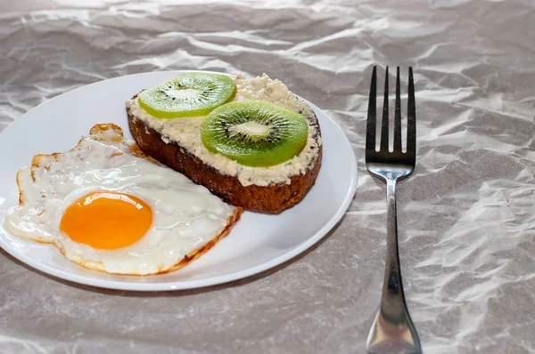 Leckeres und gesundes Frühstück. Spiegeleier und Kiwi-Sandwich auf weißem Teller, Nahaufnahme, Platz für Text — Stockfoto