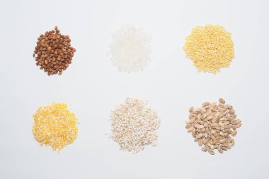 Lapa karabuğday, pirinç, darı, mısır ve arpa beyaz bir arka plan üzerinde, üstten izlendi. Diyet ve sağlıklı beslenme