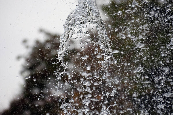 Брызги воды в фонтане, абстрактный фон. Капли воды, городские фонтаны осенью
