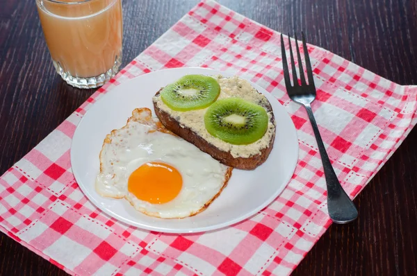 Zdravá, chutná snídaně, šťáva, chlebový sendvič s kiwi a smažené vajíčko na bílém talíři — Stock fotografie