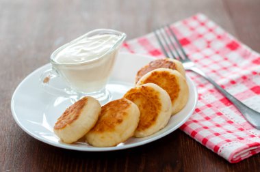 Pembe peçete ve çatal ile beyaz bir tabak üzerinde ekşi krema ile Peynir krep. Menü tasarımı için kullanılabilir.