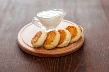 Ahşap bir tahta üzerinde ekşi krema ile Peynir krep, yatay formatta. Menü tasarımı ve cafe reklamcılığı için