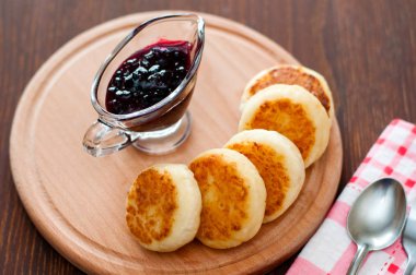 Kuş üzümü reçeli ile Peynir krep, tahta bir tahta üzerinde, bir çatal, kaşık ve bulaşık bezi görünümü ile üstten