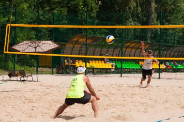 Ukrayna, Chernigov, 9 Haziran 2019: Şehrin Plaj Voleybolu Şampiyonası. Güzel genç spor güçlü erkekler şehir plajında voleybol oynamak, yaz aylarında, güneşli sıcak havalarda.