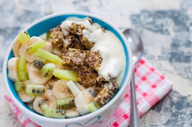 Granola, kivi, muz ve Yunan yoğurt gri beton arka plan üzerinde bir kase içinde, kırmızı bir peçete üzerinde, üstten alan görünümü kopyalayın. Kilo kaybı, doğru beslenme ve sağlıklı bir yaşam tarzı için Fitness diyet