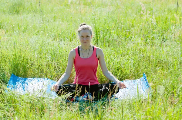 Jovem mulher bonita fazendo ioga na natureza no verão. Menina esbelta medita na manhã ensolarada . — Fotografia de Stock