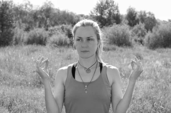 Retrato blanco y negro de una hermosa mujer haciendo yoga sobre la naturaleza en el verano en un prado — Foto de Stock