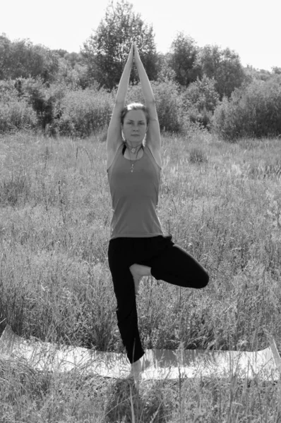 Menina bonita realizando asanas ioga ao ar livre ensolarado verão manhã bw — Fotografia de Stock