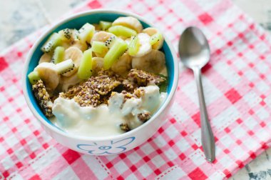 Granola yunan yoğurt kivi ve muz pembe bir peçete, yukarıdan yakından görünümü üzerinde kase içinde. Kilo kaybı, uygun ve lezzetli gıda için Fitness diyet