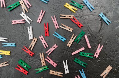 El yapımı arka plan, koyu gri beton üzerinde renkli ahşap clothespins çok, kopya alanı
