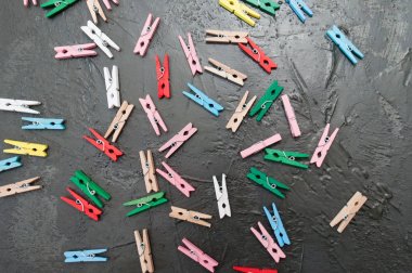 El yapımı arka plan, koyu gri beton üzerinde renkli ahşap clothespins çok, kopya alanı