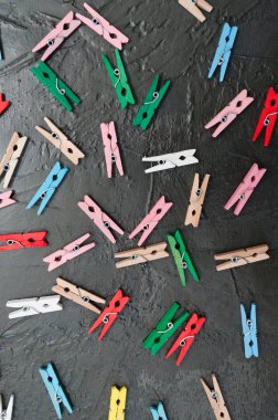El yapımı arka plan, koyu gri beton üzerinde renkli ahşap clothespins çok, kopya alanı