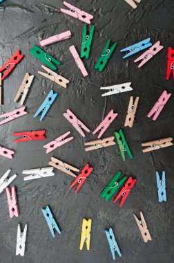 El yapımı arka plan, koyu gri beton üzerinde renkli ahşap clothespins çok, kopya alanı