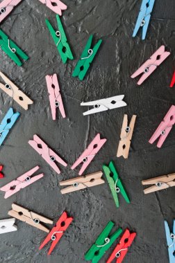 El yapımı arka plan, koyu gri beton üzerinde renkli ahşap clothespins çok, kopya alanı
