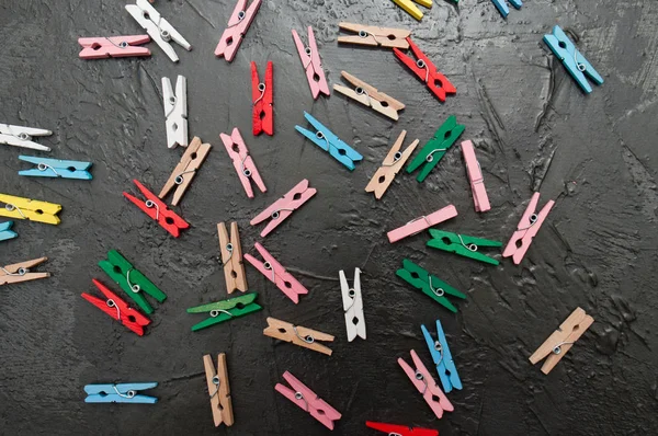Ręcznie wykonane tło, wiele kolorowych drewnianych clothespins na ciemnoszary betonu, przestrzeń kopiowania — Zdjęcie stockowe