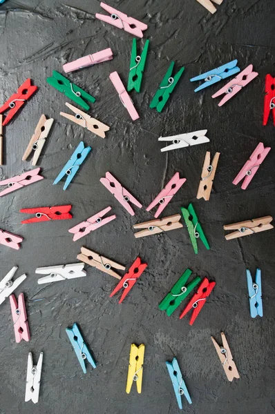 Hand made background, lot of colorful wooden clothespins on dark gray concrete, copy space — Stock Photo, Image