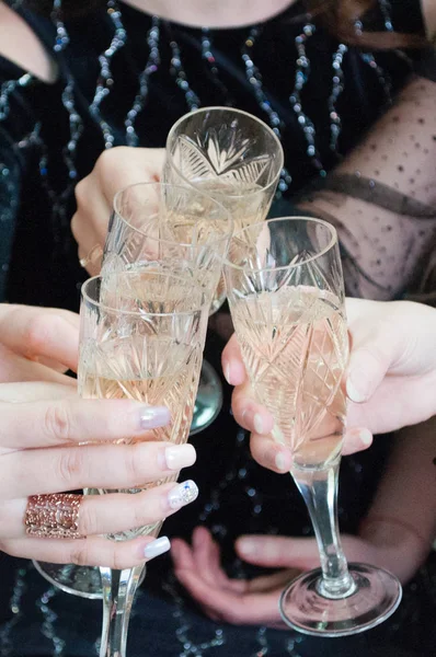 Copos festivos com champanhe em mãos femininas. Celebração de Natal, aniversário, festa de galinha, casamento — Fotografia de Stock