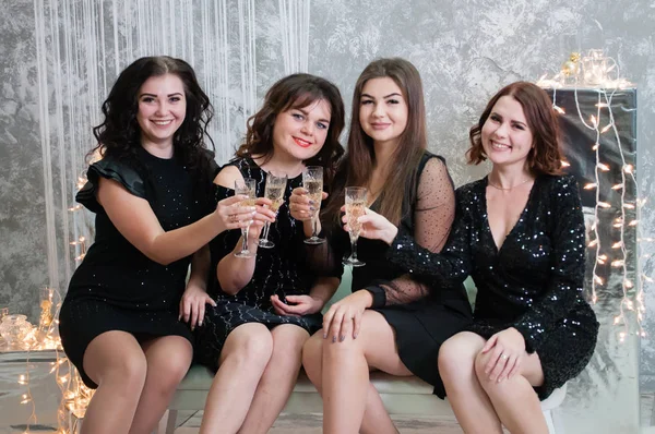 Companhia de mulheres jovens muito agradáveis com copos de vinho de champanhe celebra o Natal, o ano novo — Fotografia de Stock